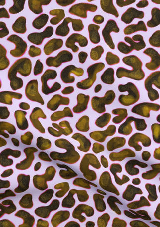 A slightly creased piece of fabric featuring an intriguing camouflage spot pattern in golden chartreuse lined in pink
