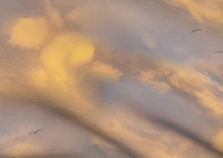 A slightly creased piece of fabric featuring the described design of gray and sulphurous yellow cloudy skies.