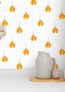 A slightly creased piece of fabric featuring golden ginkgo leaves arranged on a white-grayish textured fabric by lenes_linien.