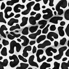 A slightly creased piece of fabric featuring an intriguing camouflage spot pattern in black and white.