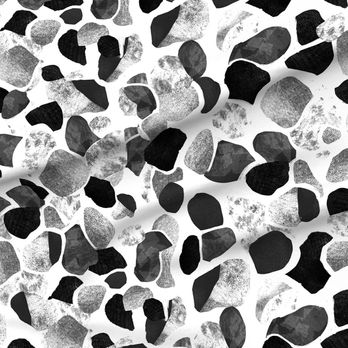 A slightly creased piece of fabric featuring abstract, textured shapes resembling mediterranean terrazzo stone floors.