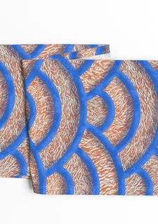 A slightly creased piece of fabric featuring Japanese Seigaiha wave scallops with a coral marble texture in blue and orange by lenes_linien.