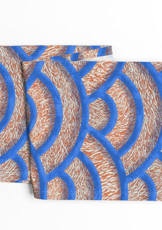 A slightly creased piece of fabric featuring Japanese Seigaiha wave scallops with a coral marble texture in blue and orange by lenes_linien.
