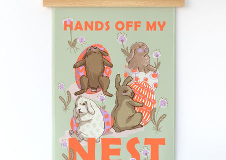 A slightly creased Tea towel featuring a design of rabbits guarding eggs, titled: Hands off my nest!