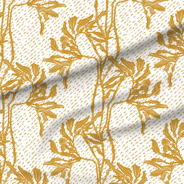 A slightly creased piece of fabric featuring an elegant duotone design of sea kelp fronds in a blockprint style.
