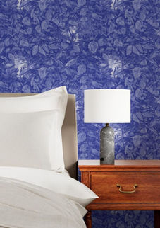 A slightly creased piece of fabric featuring dense blue foliage with hidden faces and insects by lenes_linien.