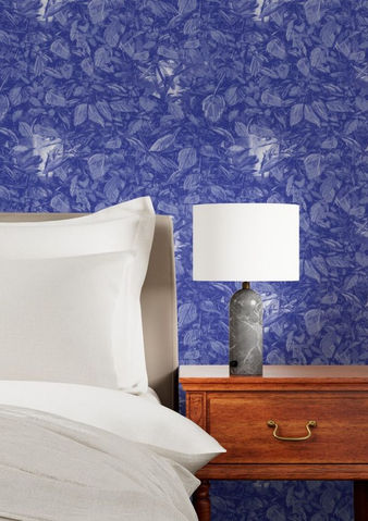 A slightly creased piece of fabric featuring dense blue foliage with hidden faces and insects by lenes_linien.