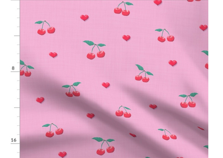 A slightly creased piece of fabric featuring a design  of red cherries with green stems and vertical stripes on soft pink by lenes_linien