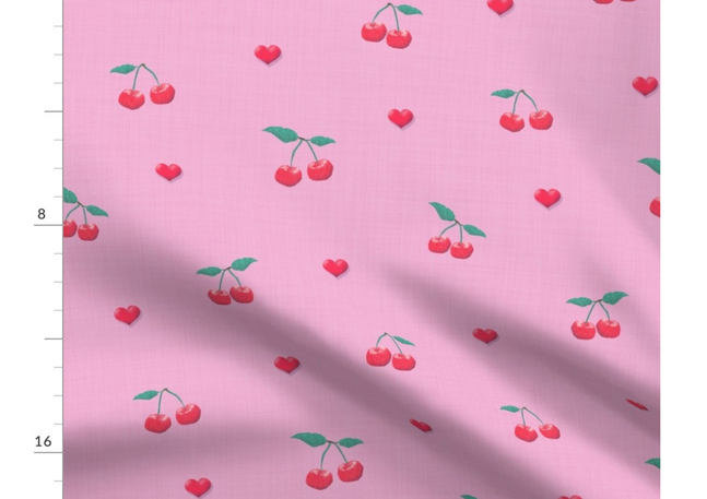 A slightly creased piece of fabric featuring a design  of red cherries with green stems and vertical stripes on soft pink by lenes_linien