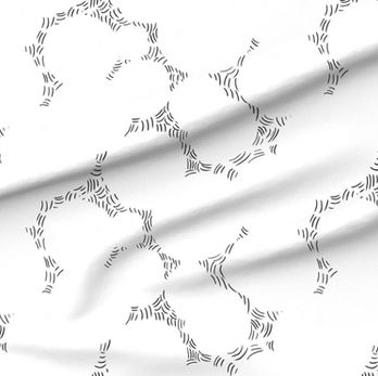 A slightly creased piece of fabric showing a design of intersecting ornamental circles framed by scattered stitches.