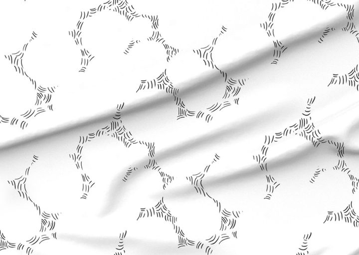 A slightly creased piece of fabric showing a design of intersecting ornamental circles framed by scattered stitches.