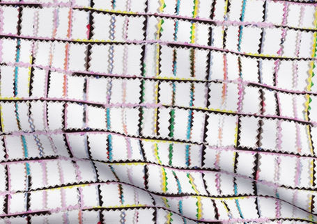 A slightly creased piece of fabric featuring punky colorful zigzag trimmings arranged in grid format on white.