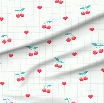 A slightly creased piece of fabric featuring a design of red cherries with green stems, little hearts and a green grid on white by lenes_linien