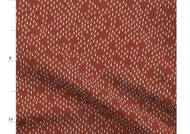 A slightly creased piece of fabric featuring the described raindrop and holes matrix design by lenes_linien