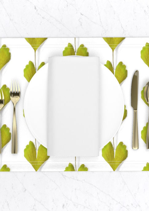 A slightly creased piece of fabric featuring vibrant chartreuse ginkgo leaves in vertical lines by lenes_linien.
