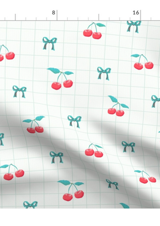 A slightly creased piece of fabric featuring a design  of red cherries with green stems, little hearts and a green grid on white by lenes_linien