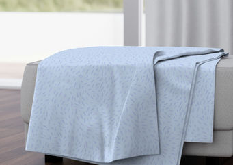 A slightly creased rectangle of fabric showing a dynamic, abstract ditsy design of lively whirls on unicolored ground.