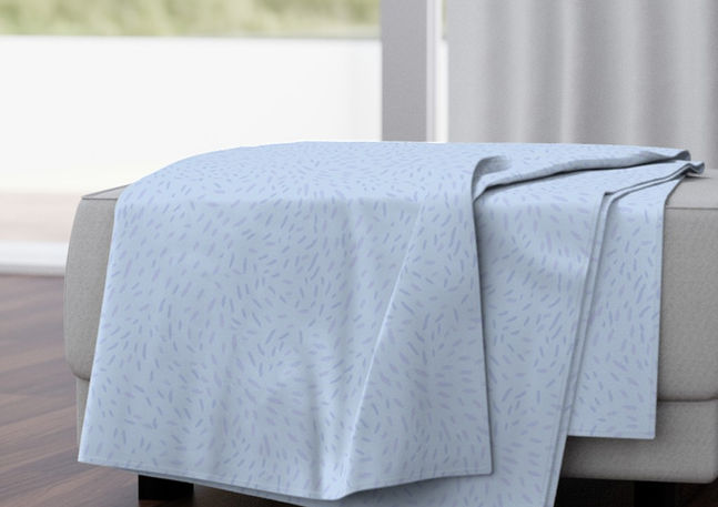 A slightly creased rectangle of fabric showing a dynamic, abstract ditsy design of lively whirls on unicolored ground.