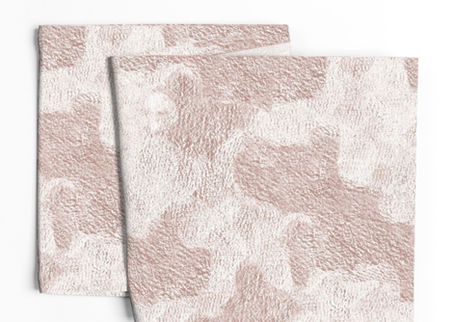 A slightly creased piece of fabric featuring abstract rugged stone-like shapes in blush pink and cream by lenes_linien.