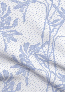 A slightly creased piece of fabric featuring an elegant duotone design of sea kelp fronds in a blockprint style.