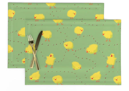 A slightly creased piece of fabric featuring fluffy yellow chicks pecking at dotted corn on a green ground by lenes_linien.