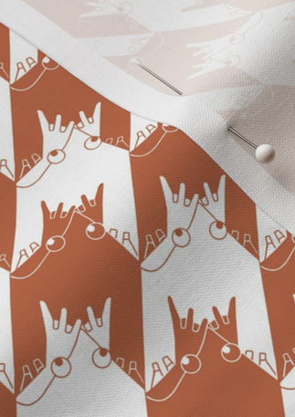 A slightly creased piece of fabric featuring a geometrical houndstooth design composed of abstracted frogs by lenes_linien