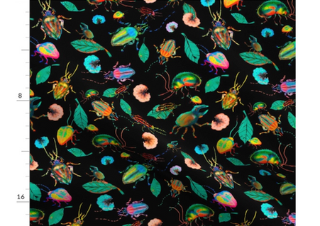A slightly creased rectangle of fabric showing colorful bugs against deep black background.