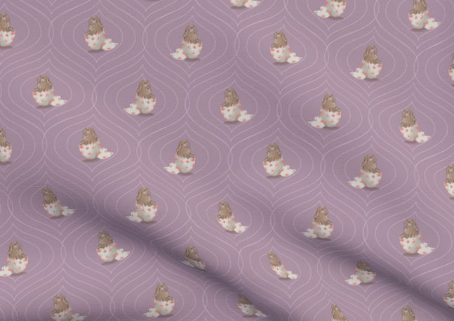 A slightly creased piece of fabric featuring baby bunnies sitting in easter egg shells, sticking out their tongues.