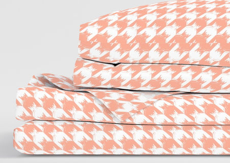 A slightly creased piece of fabric featuring a geometrical houndstooth design composed of abstracted frogs by lenes_linien