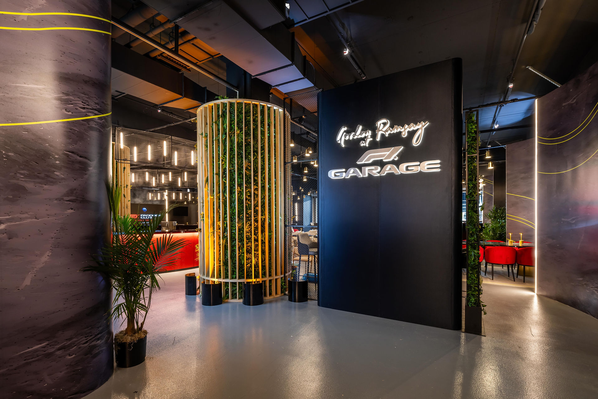 Entrance to F1 Garage hospitality lounge with vertical garden and neon signage