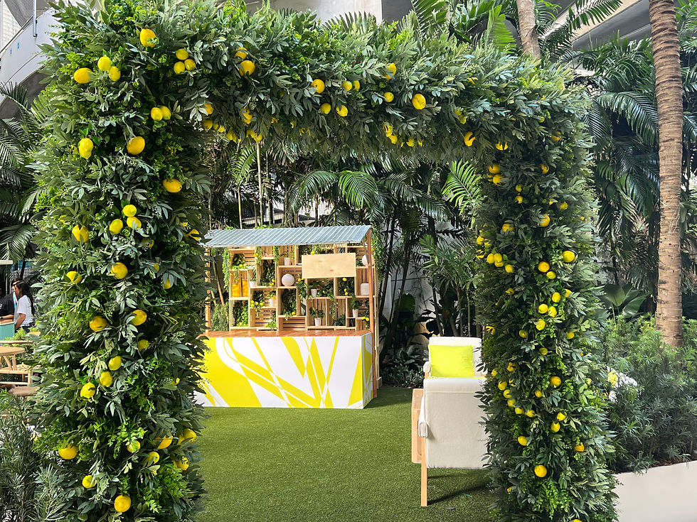 Greenery archway adorned with lemons at a garden-inspired event entrance