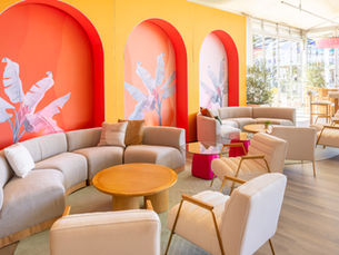 Colorful lounge with curved beige sofas, armchairs, and tropical wall arches by event design studio