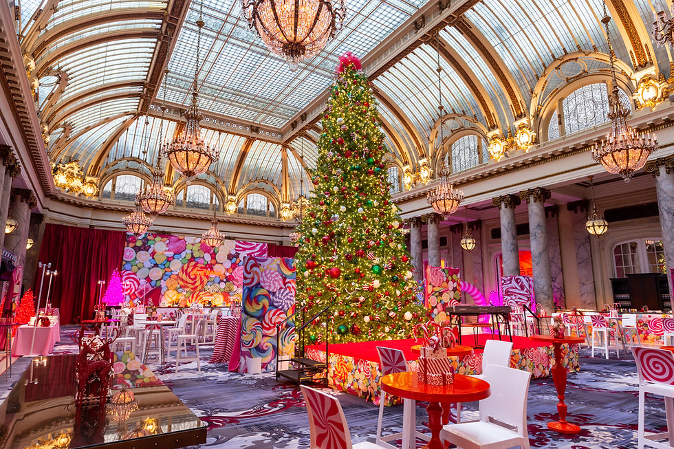 Candyland-themed holiday party with giant Christmas tree in a grand chandelier-lit ballroom