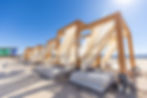 Daytime desert cabanas with sheer drapes and lounge cushions at an outdoor event