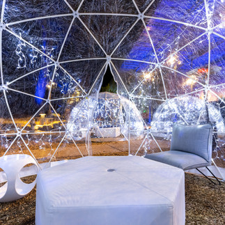 Interior of glowing winter dome with modern white furniture and twinkle lights