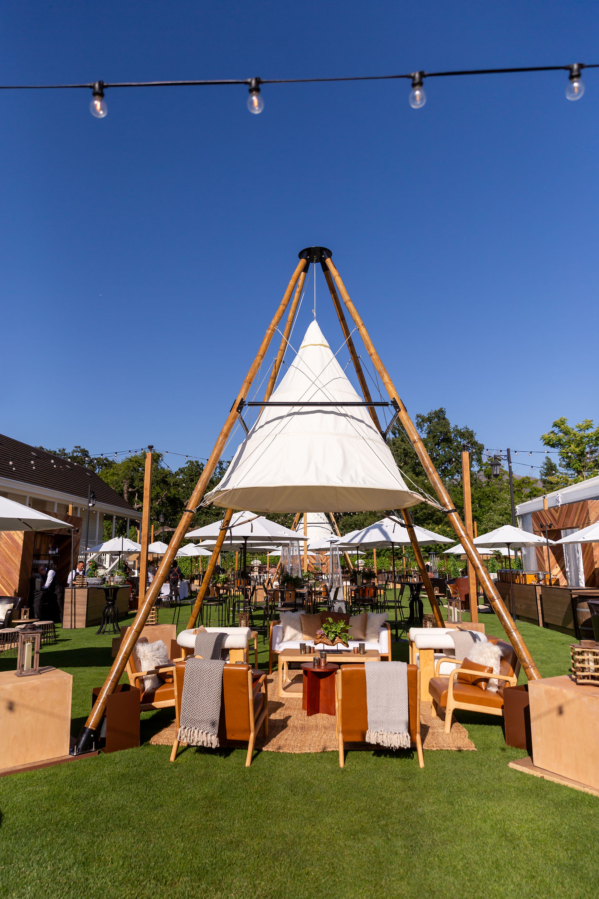 Bamboo tepee structure and casual seating for open-air summer event design