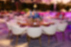 Elegant gala dining setup with gold chairs and colorful centerpieces