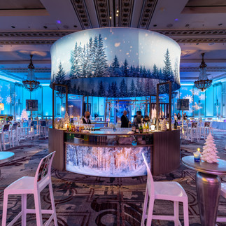 Immersive winter-themed bar with forest canopy and LED-lit décor