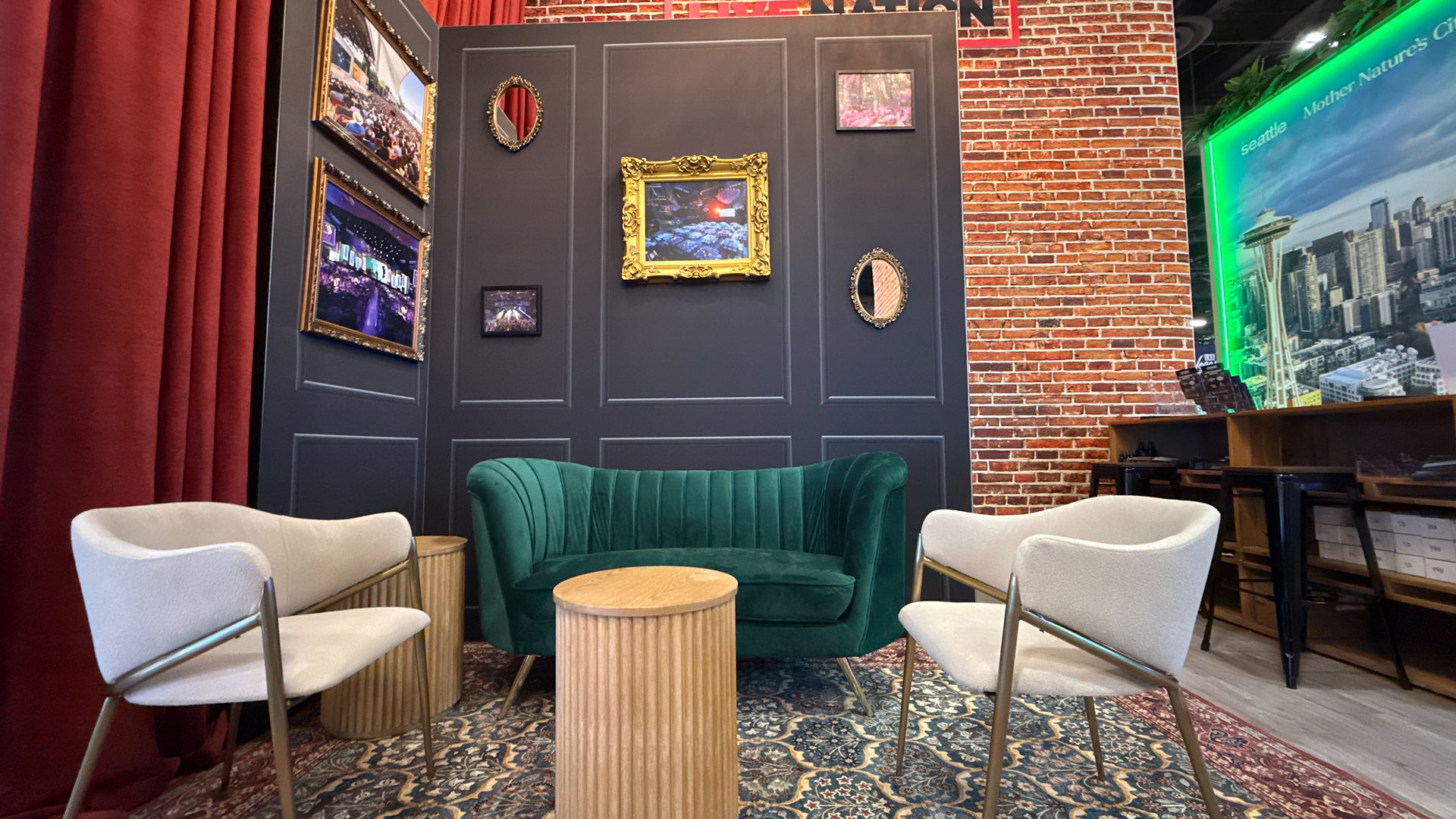Scenic lounge setup with green velvet sofa, boucle chairs, and ornate picture frames.