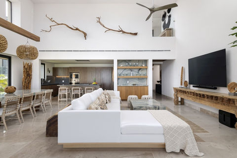 Professional Interior Design Image of a Luxury Vacation Home or Contemporary Great Room with a Custom White Sofa Chaise, Natural Branches on the Wall, Custom Dry Bar, Custom Coffee Table and Custom Dining Table with Blue Azul Macaubus Stone, Punta Mita Mexico