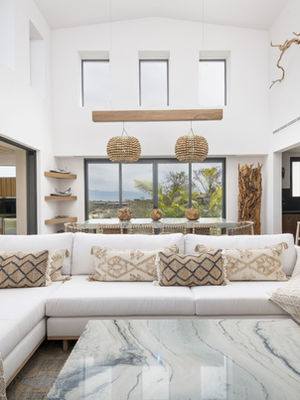Stunning living room with panoramic ocean views, contemporary furnishings, and soft neutral tones.