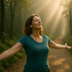 Woman standing in sunlight on woodland path with arms open – symbol of emotional release and personal breakthrough