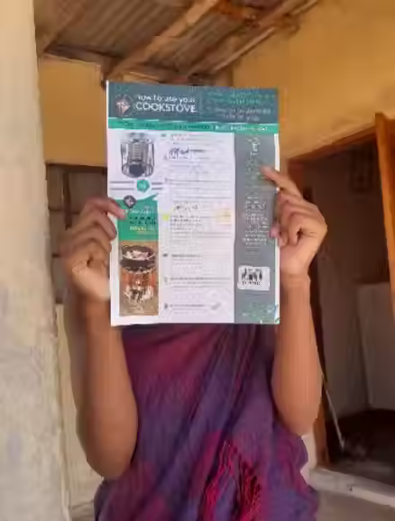 A person holding a token in exchange for a cookstove Source: TASC.