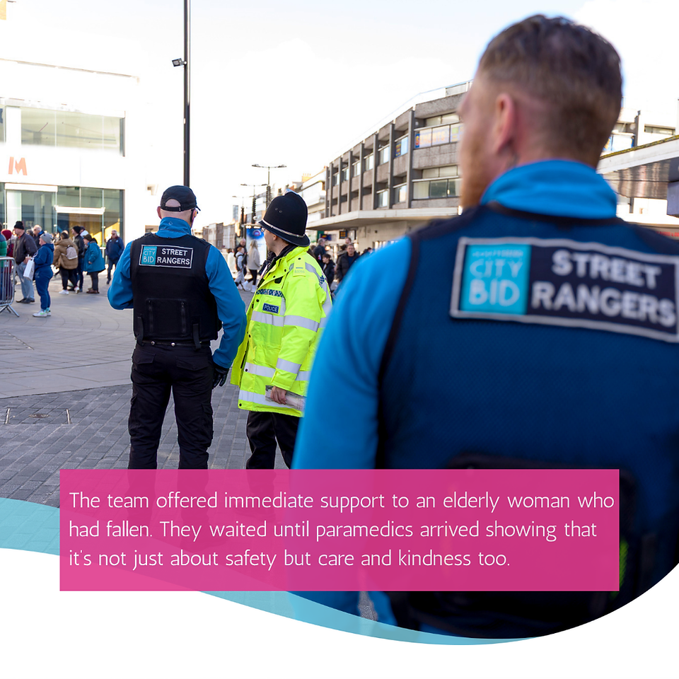 in the foreground is the back of a street ranger and you can see the logo on his back for Southend  City BID. In the back ground a street ranger speaks with a police officer in a high vis coat and black hat.