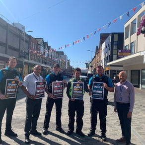 Officers stand in Southend High Street holding 'Just Here to Work' campaign posters