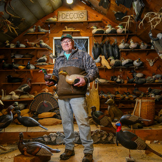 Steve Brettell holds a drake eider and wood duck at his workshop in Biddeford, Maine.