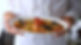 A chef presents a pasta dish with lobster, shrimp and clams.