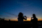 Ashley and Tina photograph the sunset from their rooftop in downtown Biddeford.