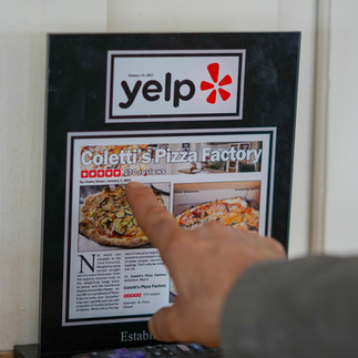 Frank Coletti, owner of Coletti's Pizza in Biddeford, Maine, points to his Yelp write up on Monday, March 30, 2026.