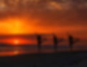 A yoga class at sunrise on the beach.